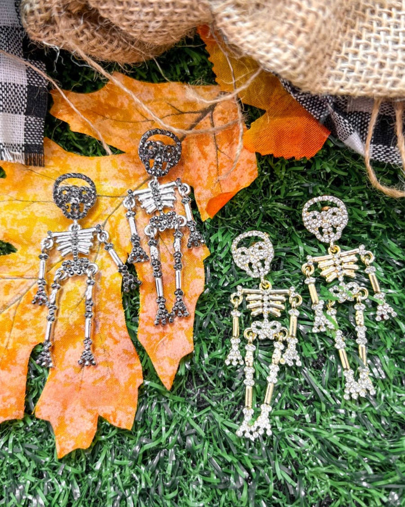 gold-plated post-back skeleton-shaped dangle earrings with rhinestone accents, skull stud tops, articulated bone design, matching barrel backs, and nickel/lead compliant construction in gold and silver