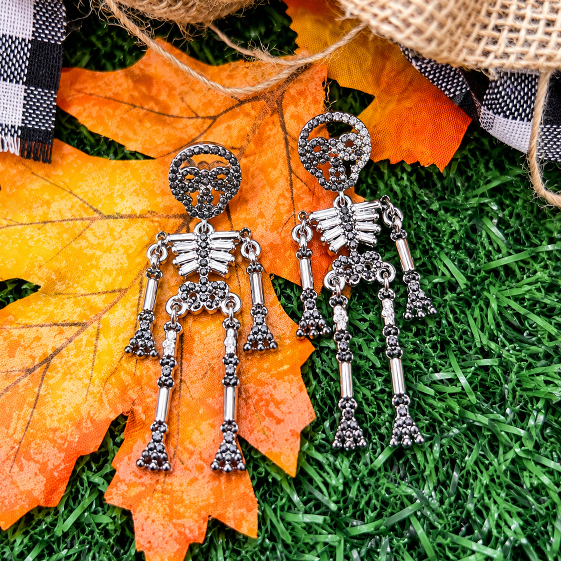 gold-plated post-back skeleton-shaped dangle earrings with rhinestone accents, skull stud tops, articulated bone design, matching barrel backs, and nickel/lead compliant construction in silver