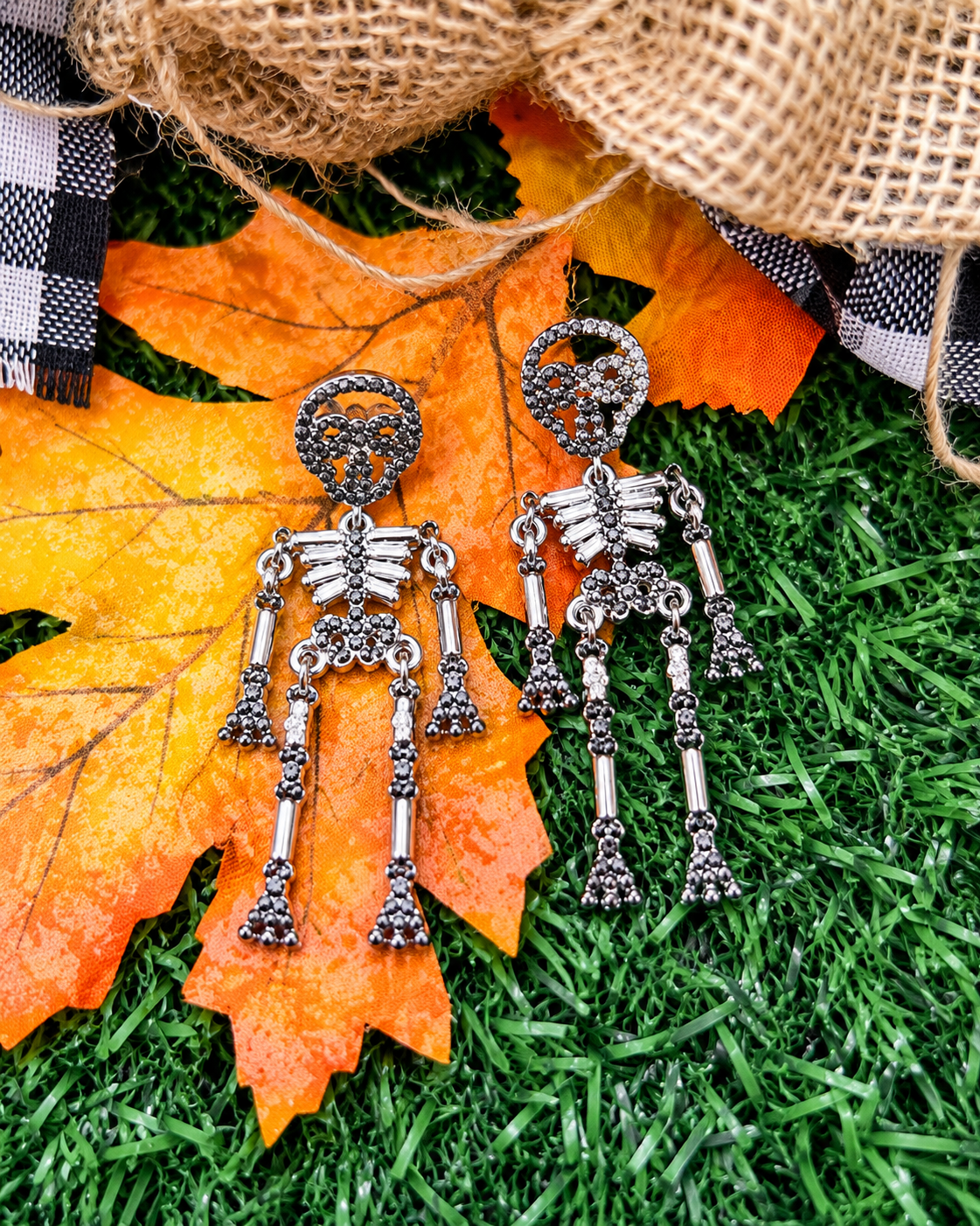 gold-plated post-back skeleton-shaped dangle earrings with rhinestone accents, skull stud tops, articulated bone design, matching barrel backs, and nickel/lead compliant construction in silver