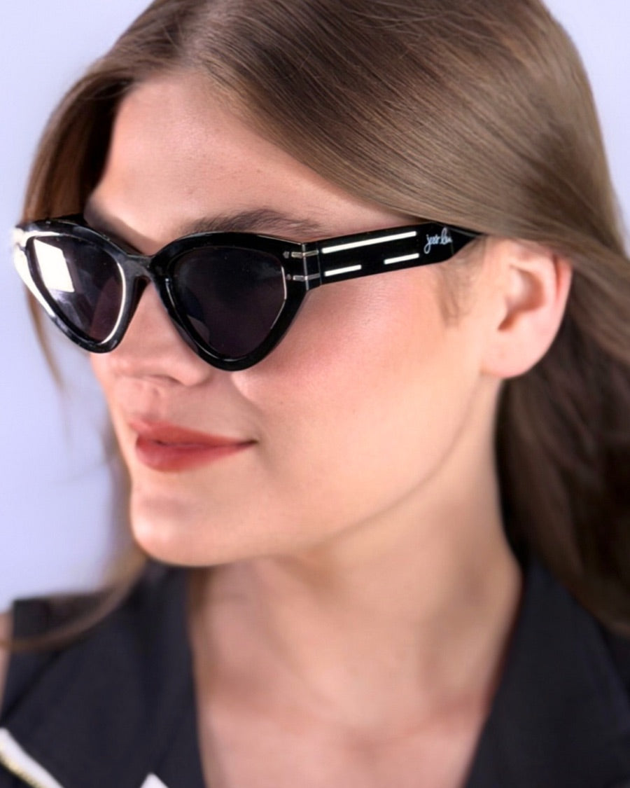 glossy black cat-eye sunglasses with dark lenses, silver and white raised accent on the temple, and brand name detail (on both the temple and the complimentary black pouch)