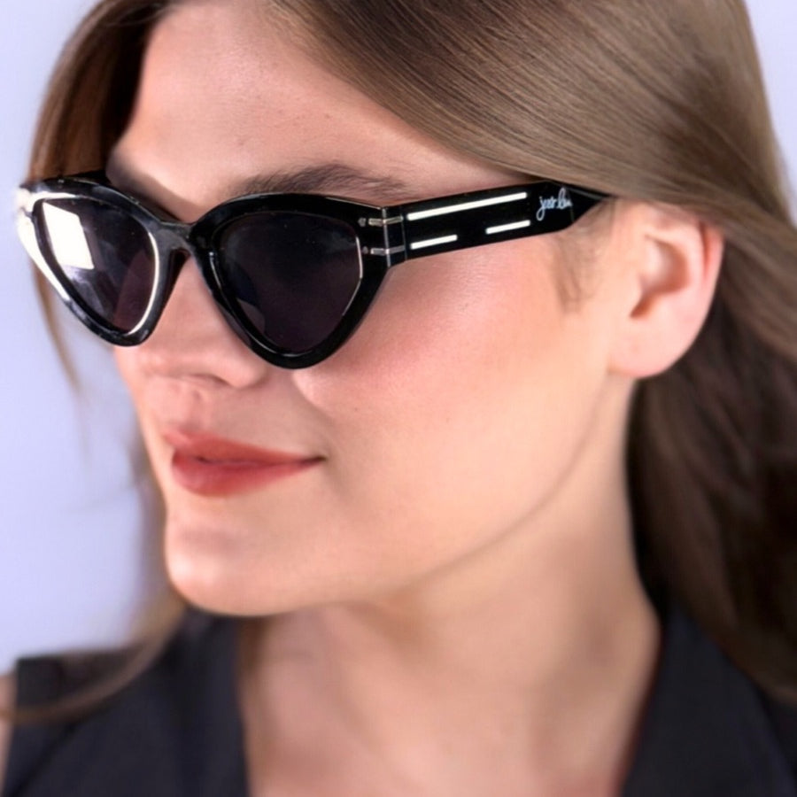 glossy black cat-eye sunglasses with dark lenses, silver and white raised accent on the temple, and brand name detail (on both the temple and the complimentary black pouch)