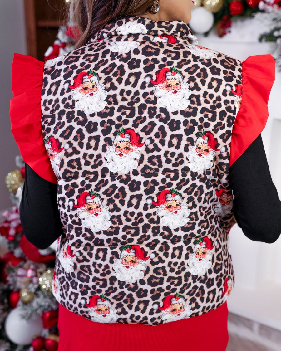 lightweight quilted puffer vest with a playful vintage Santa print on a bold leopard pattern, snap-front closure, flattering fit, practical pockets, and whimsical red ruffle shoulder detail