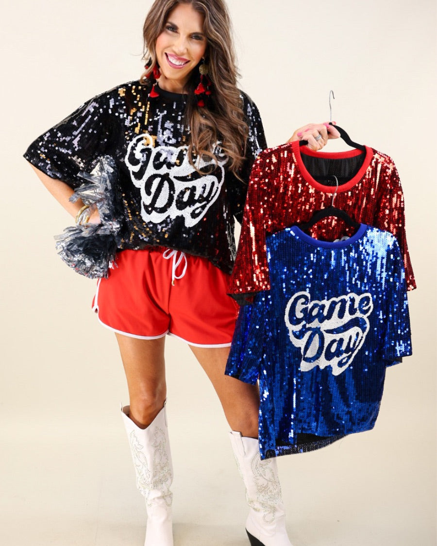 a full sequin design top on a solid color with the words 'Game Day" on the center front outlined in white sequins, a boxy fit, and a lined interior in black, red, and royal blue