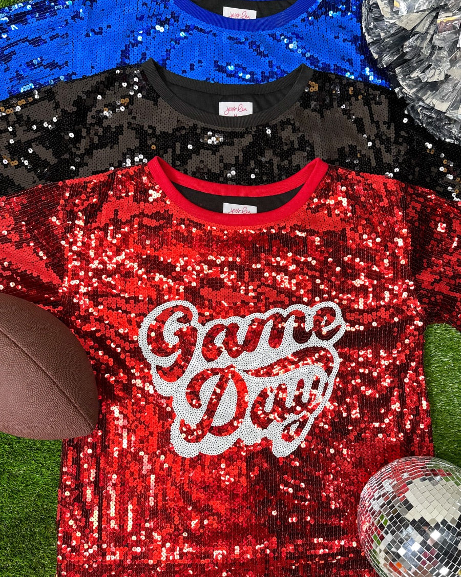 a full sequin design top on a solid color with the words 'Game Day" on the center front outlined in white sequins, a boxy fit, and a lined interior in black, red, and royal blue