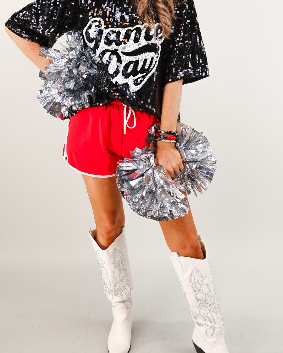 a full sequin design top on a solid color with the words 'Game Day" on the center front outlined in white sequins, a boxy fit, and a lined interior in black