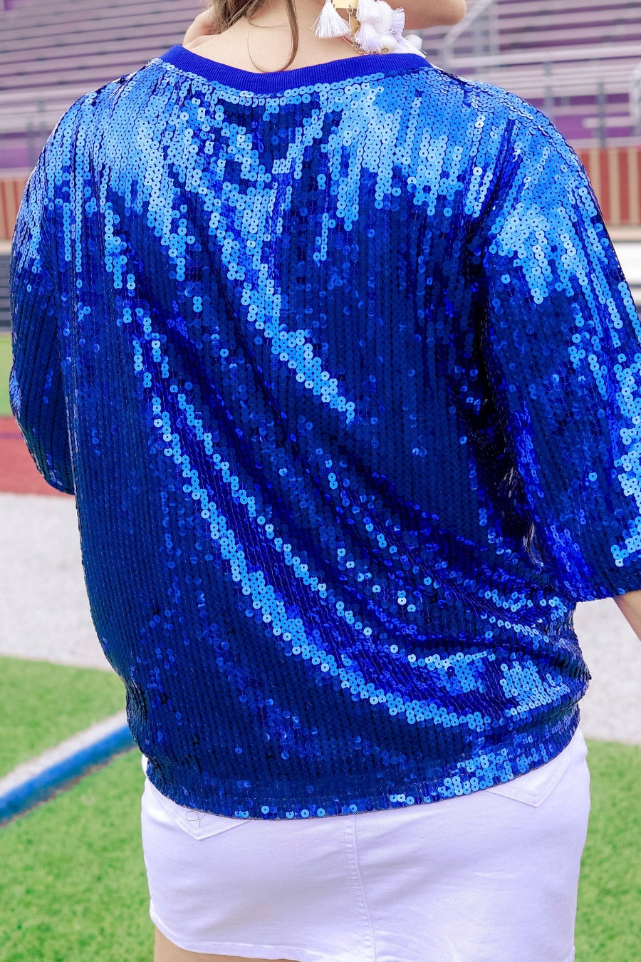 a full sequin design top on a solid color with the words 'Game Day" on the center front outlined in white sequins, a boxy fit, and a lined interior in royal blue