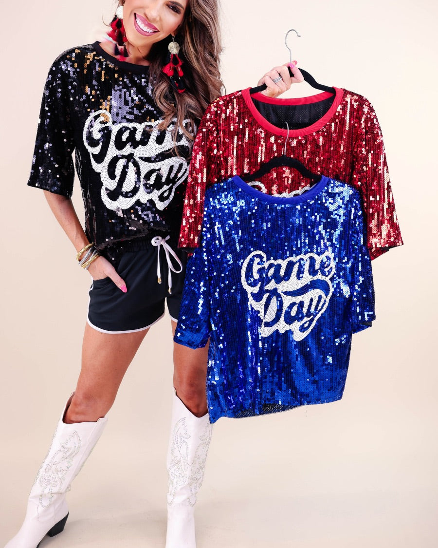 a full sequin design top on a solid color with the words 'Game Day" on the center front outlined in white sequins, a boxy fit, and a lined interior in black, red, and royal blue