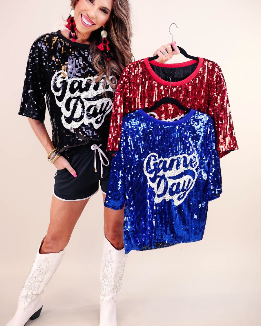 a full sequin design top on a solid color with the words 'Game Day" on the center front outlined in white sequins, a boxy fit, and a lined interior in black, red, and royal blue