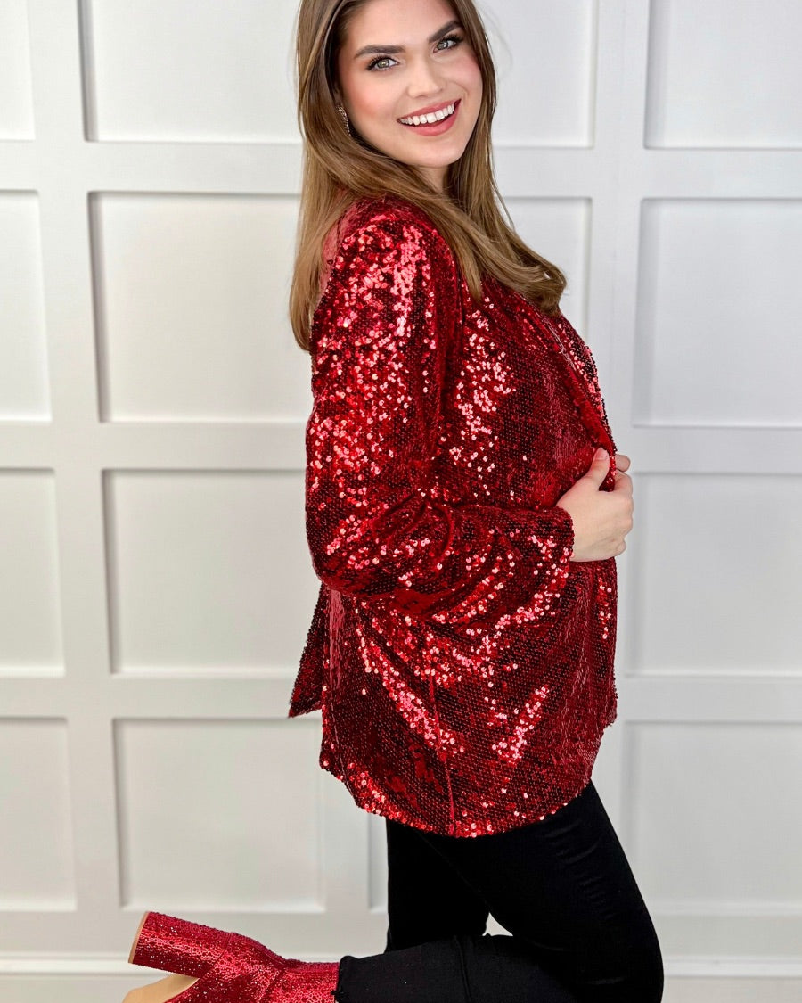 a full sequin-covered long-sleeve blazer with a structured collar, subtle shoulder pads, a smooth interior lining, and a center back vent in red