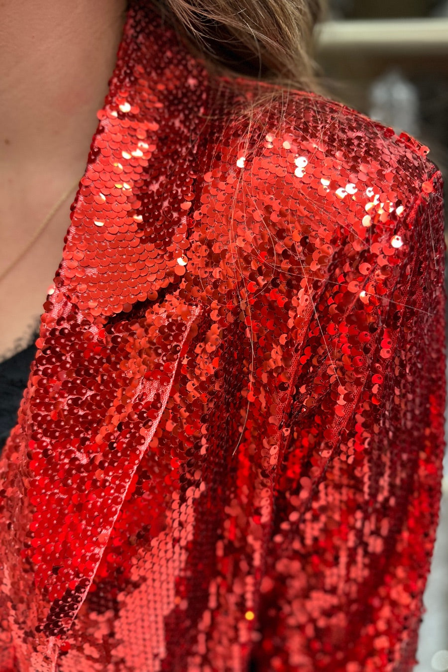 a full sequin-covered long-sleeve blazer with a structured collar, subtle shoulder pads, a smooth interior lining, and a center back vent in red