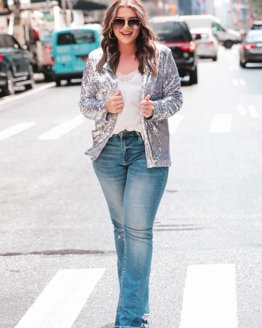 a full sequin-covered long-sleeve blazer with a structured collar, subtle shoulder pads, a smooth interior lining, and a center back vent in silver