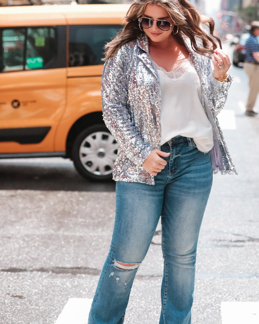 a full sequin-covered long-sleeve blazer with a structured collar, subtle shoulder pads, a smooth interior lining, and a center back vent in silver