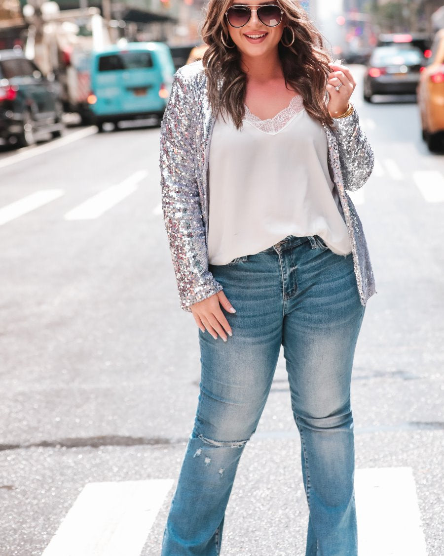 a full sequin-covered long-sleeve blazer with a structured collar, subtle shoulder pads, a smooth interior lining, and a center back vent in silver