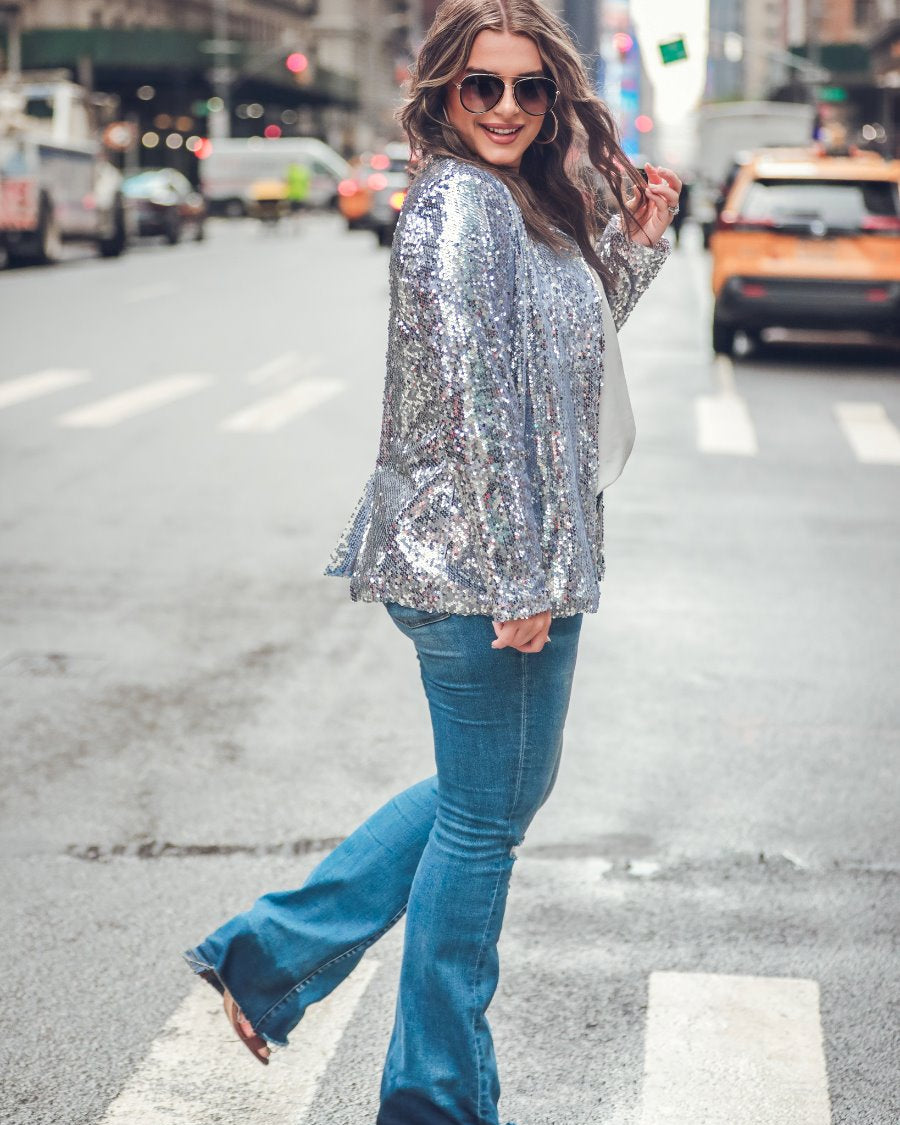 a full sequin-covered long-sleeve blazer with a structured collar, subtle shoulder pads, a smooth interior lining, and a center back vent in silver