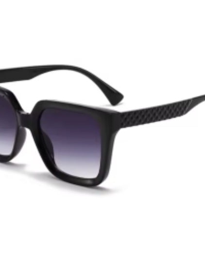 oversized square sunglasses in black with dark lenses, a raised geometric texture on the temples, and brand name detail (on both the temple and the complimentary black pouch)