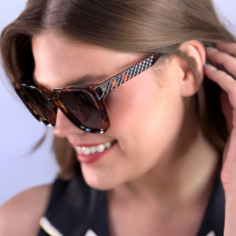 oversized square sunglasses in tortoise with dark lenses, a raised geometric texture on the temples, and brand name detail (on both the temple and the complimentary black pouch)