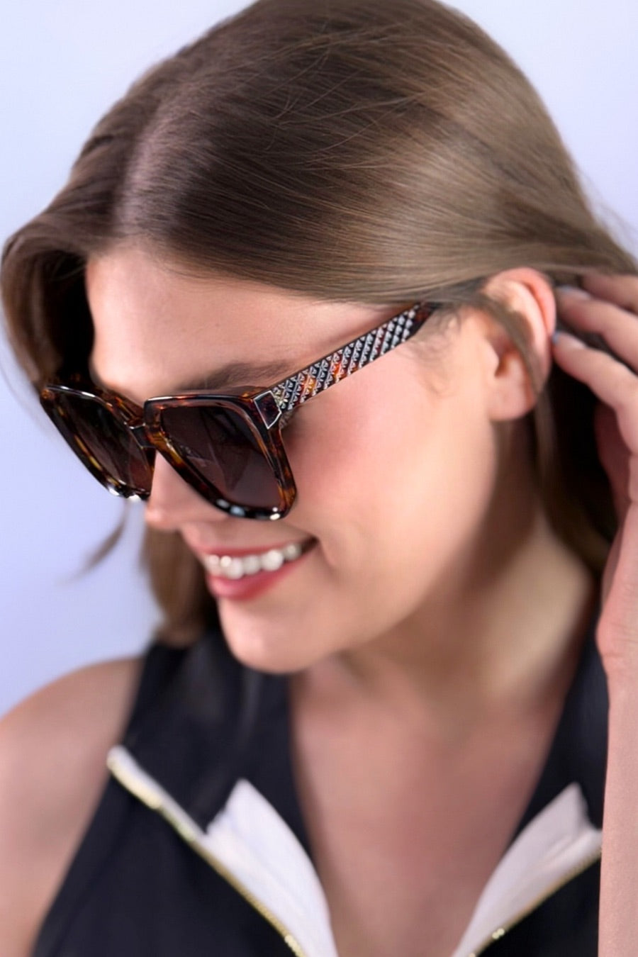 oversized square sunglasses in tortoise with dark lenses, a raised geometric texture on the temples, and brand name detail (on both the temple and the complimentary black pouch)