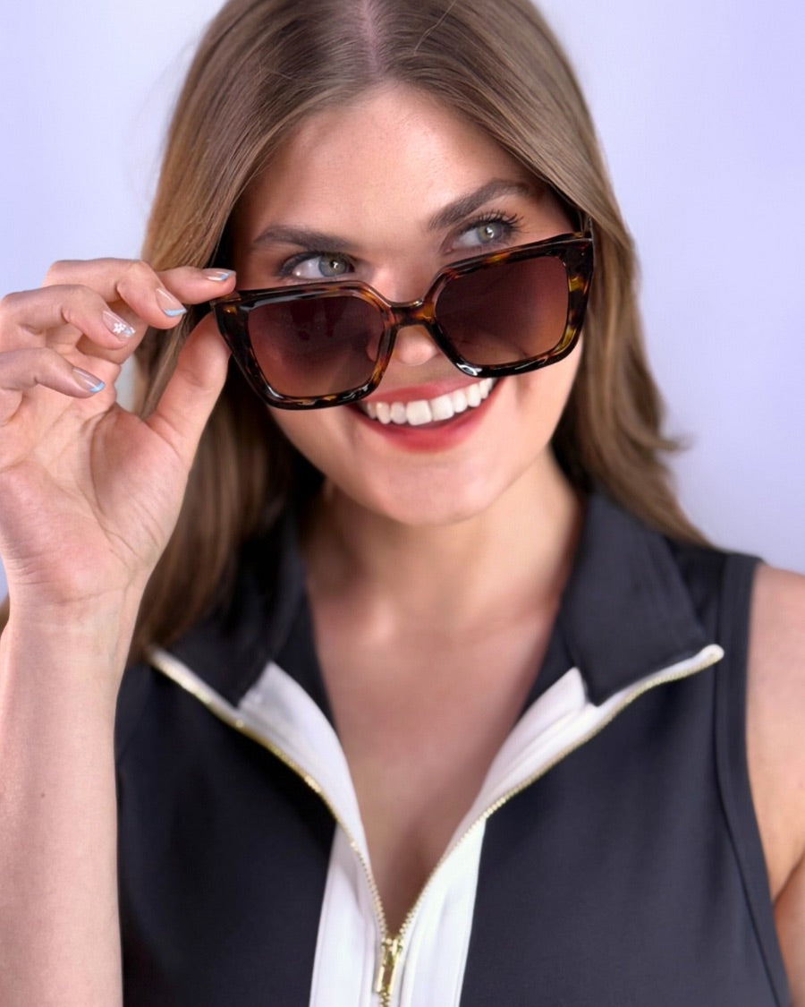 oversized square sunglasses in tortoise with dark lenses, a raised geometric texture on the temples, and brand name detail (on both the temple and the complimentary black pouch)