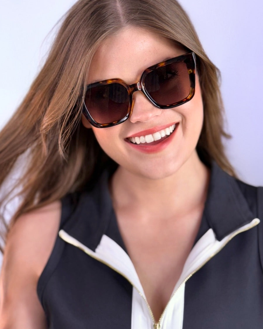 oversized square sunglasses in tortoise with dark lenses, a raised geometric texture on the temples, and brand name detail (on both the temple and the complimentary black pouch)