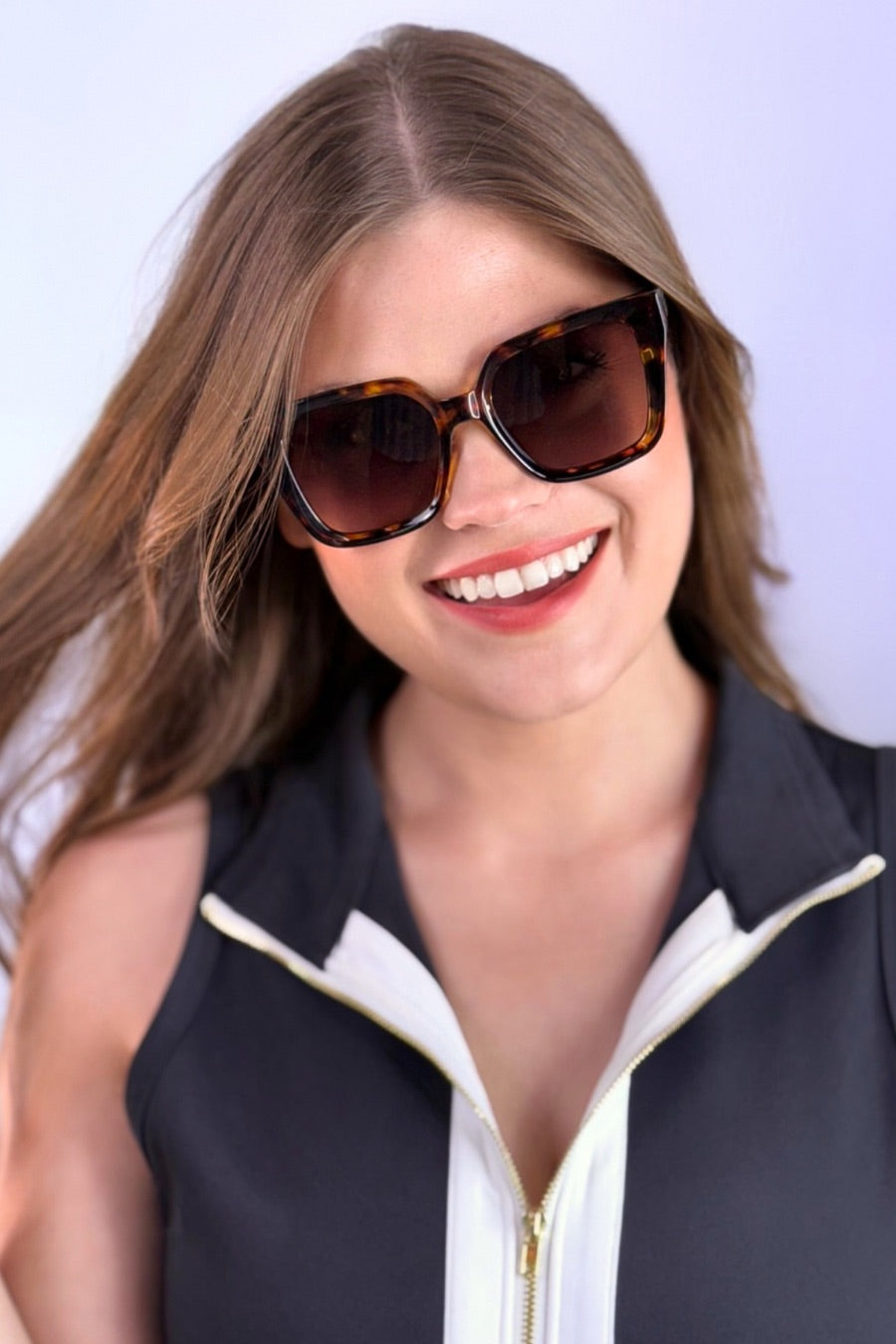 oversized square sunglasses in tortoise with dark lenses, a raised geometric texture on the temples, and brand name detail (on both the temple and the complimentary black pouch)