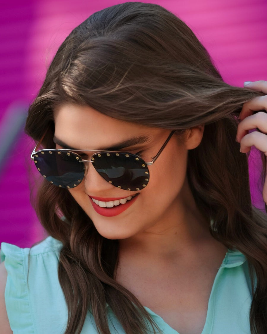 black aviator sunglasses with black tinted lenses, mini gold stud trim along the lens edge, round wireframes with matching brow bar, UV protection, and brand detail (on both the temple and the complimentary black pouch