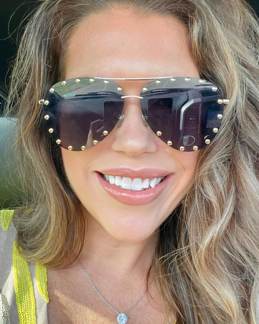 black aviator sunglasses with black tinted lenses, mini gold stud trim along the lens edge, round wireframes with matching brow bar, UV protection, and brand detail (on both the temple and the complimentary black pouch