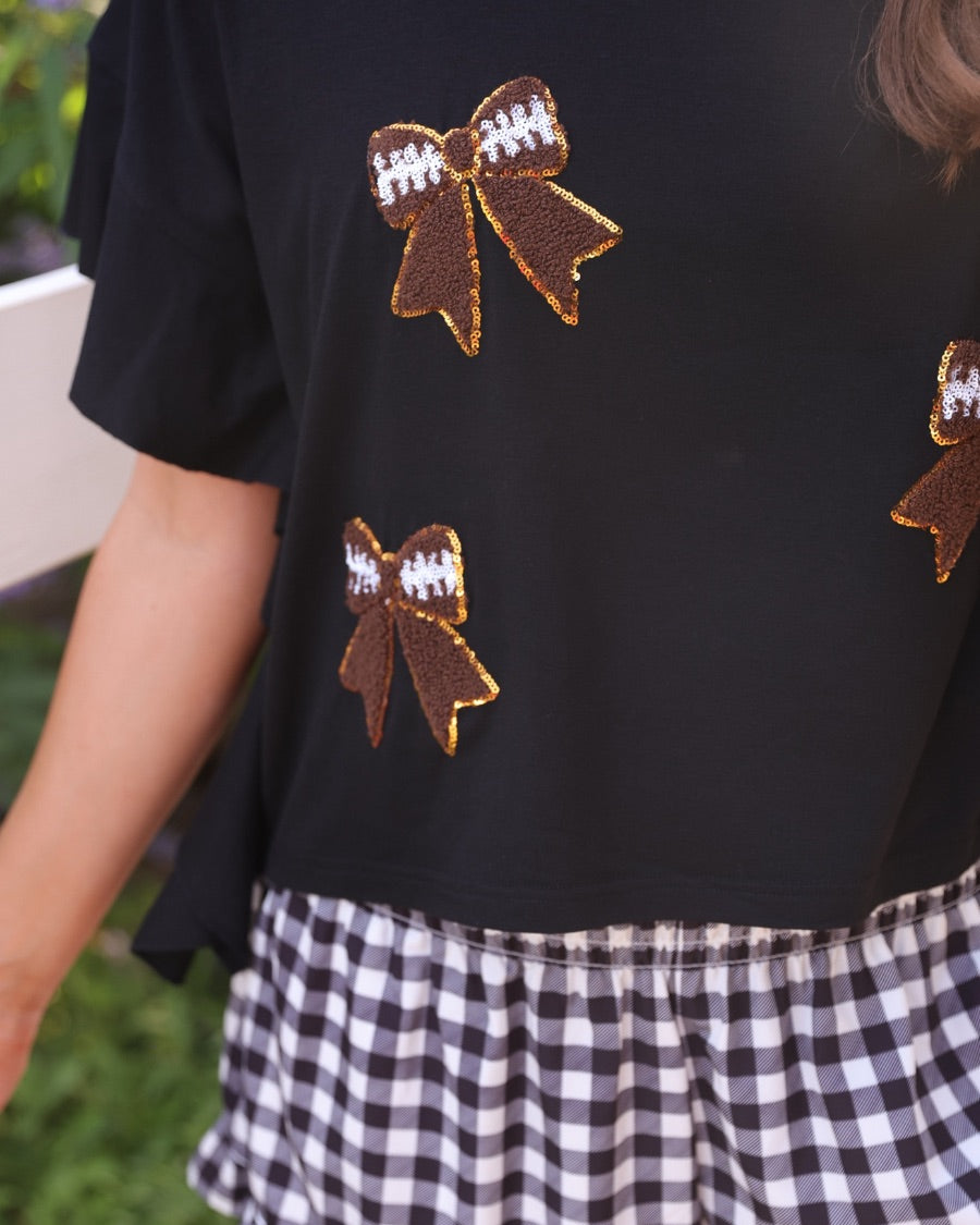 fluttery ruffle short-sleeve top with a mom crop length, sewn-on chenille football bow patches outlined in sequins on a soft, stretch-knit fabric in black