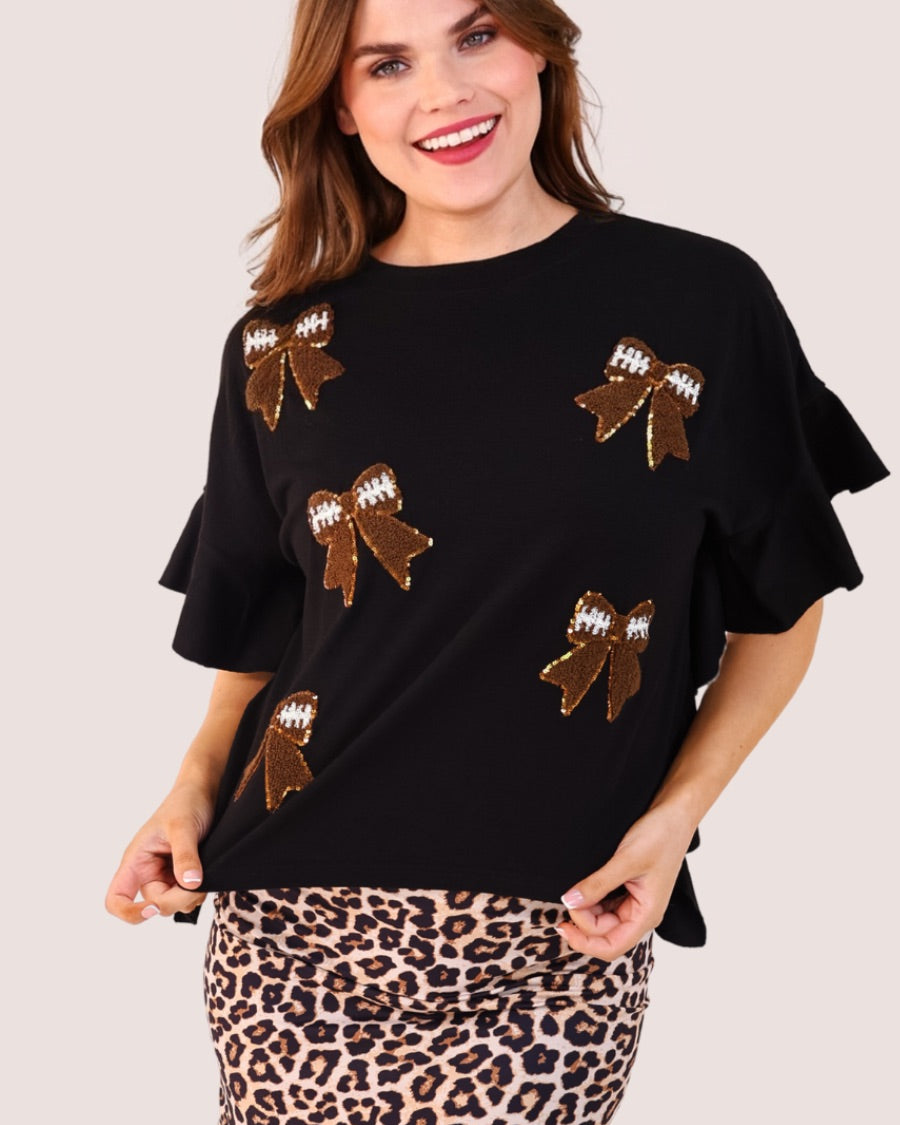 fluttery ruffle short-sleeve top with a mom crop length, sewn-on chenille football bow patches outlined in sequins on a soft, stretch-knit fabric in black