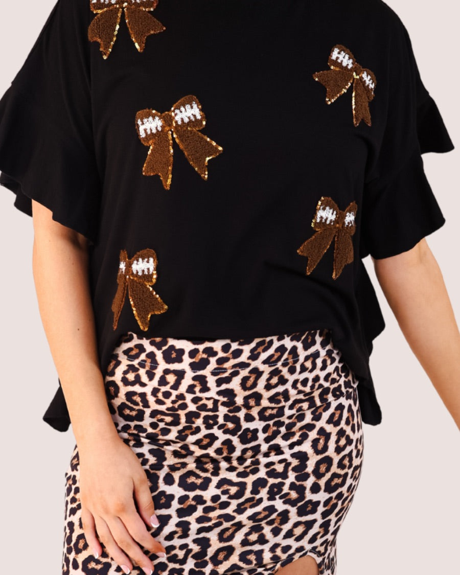 fluttery ruffle short-sleeve top with a mom crop length, sewn-on chenille football bow patches outlined in sequins on a soft, stretch-knit fabric in black