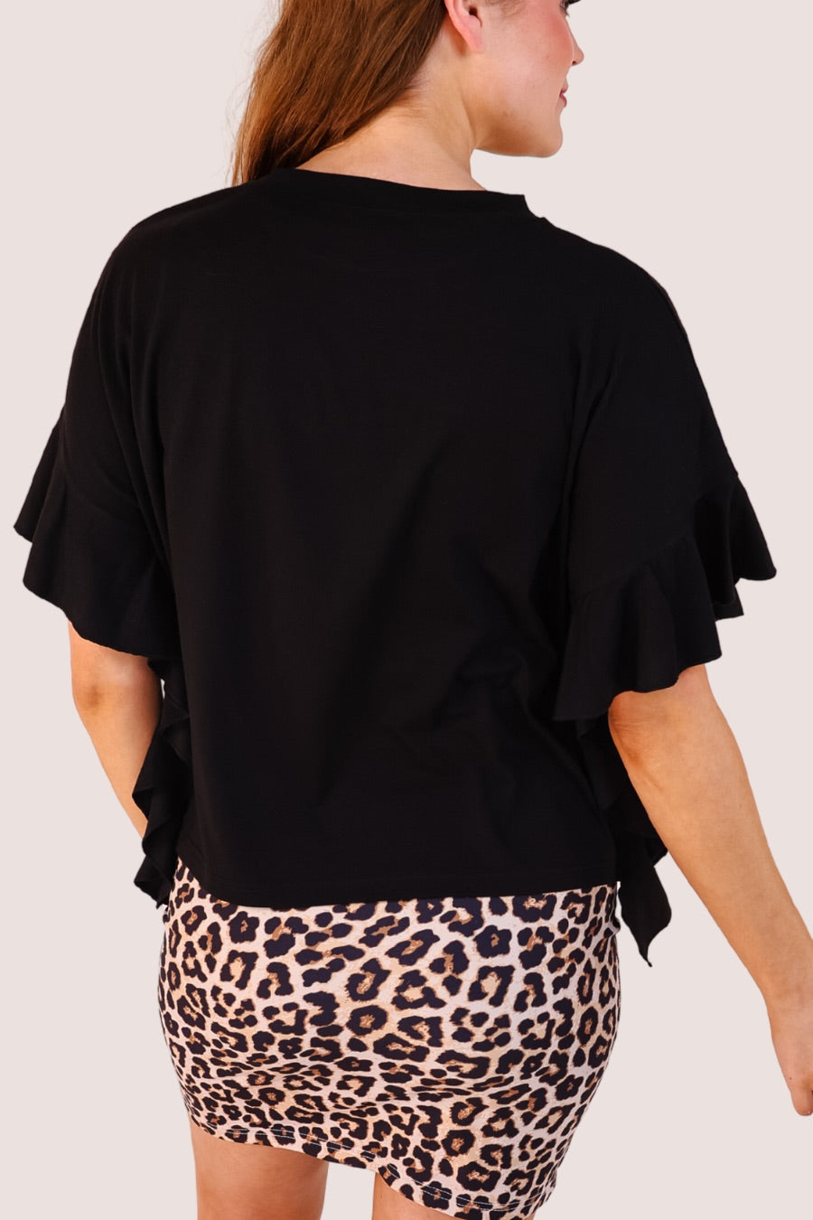 fluttery ruffle short-sleeve top with a mom crop length, sewn-on chenille football bow patches outlined in sequins on a soft, stretch-knit fabric in black