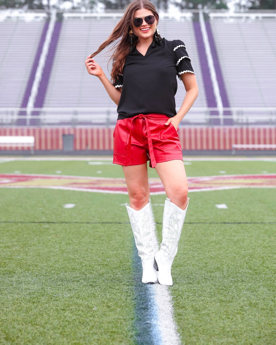 a playful V-neckline top with a ric rac trim detailing on the layered ruffled short sleeves