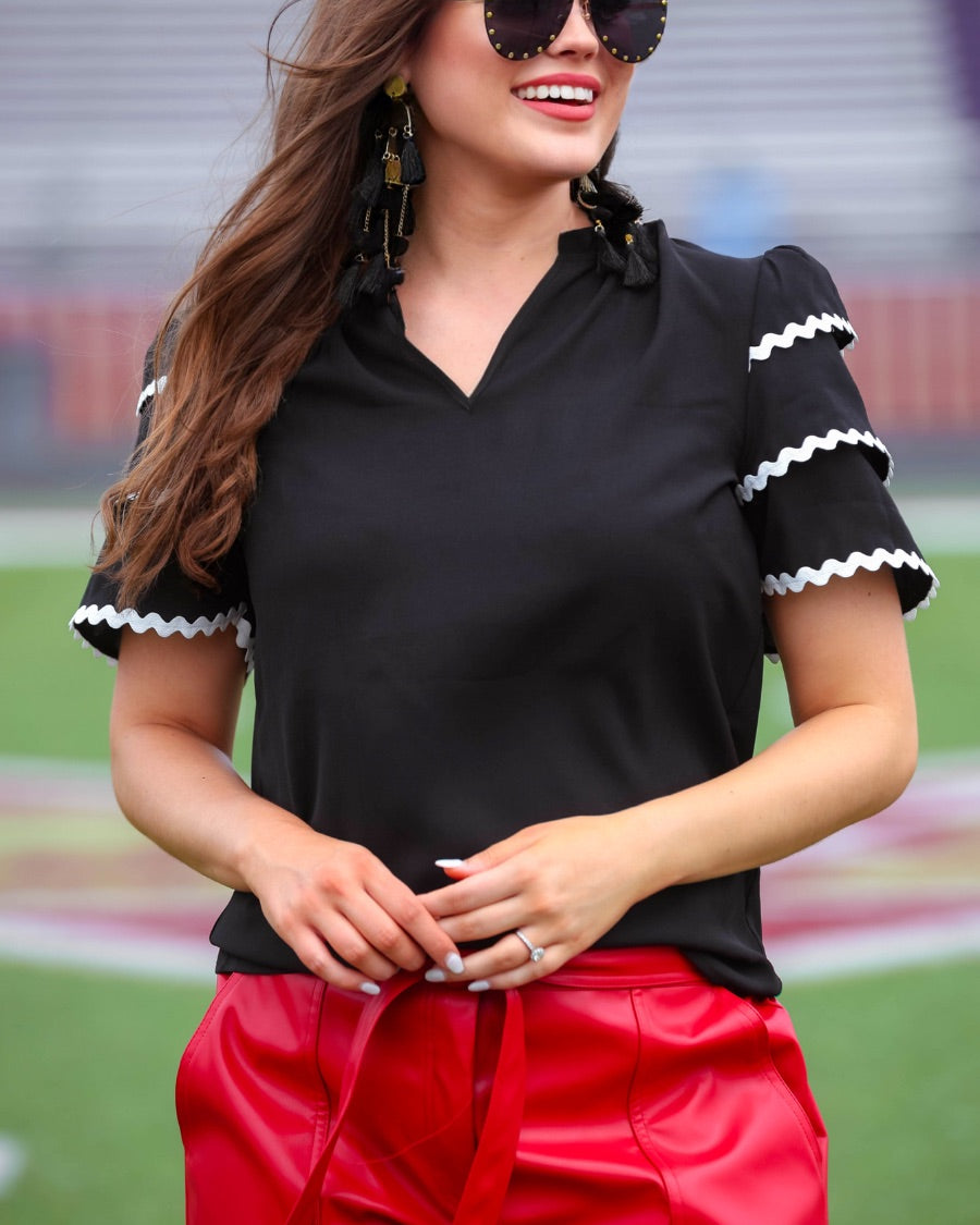 a playful V-neckline top with a ric rac trim detailing on the layered ruffled short sleeves