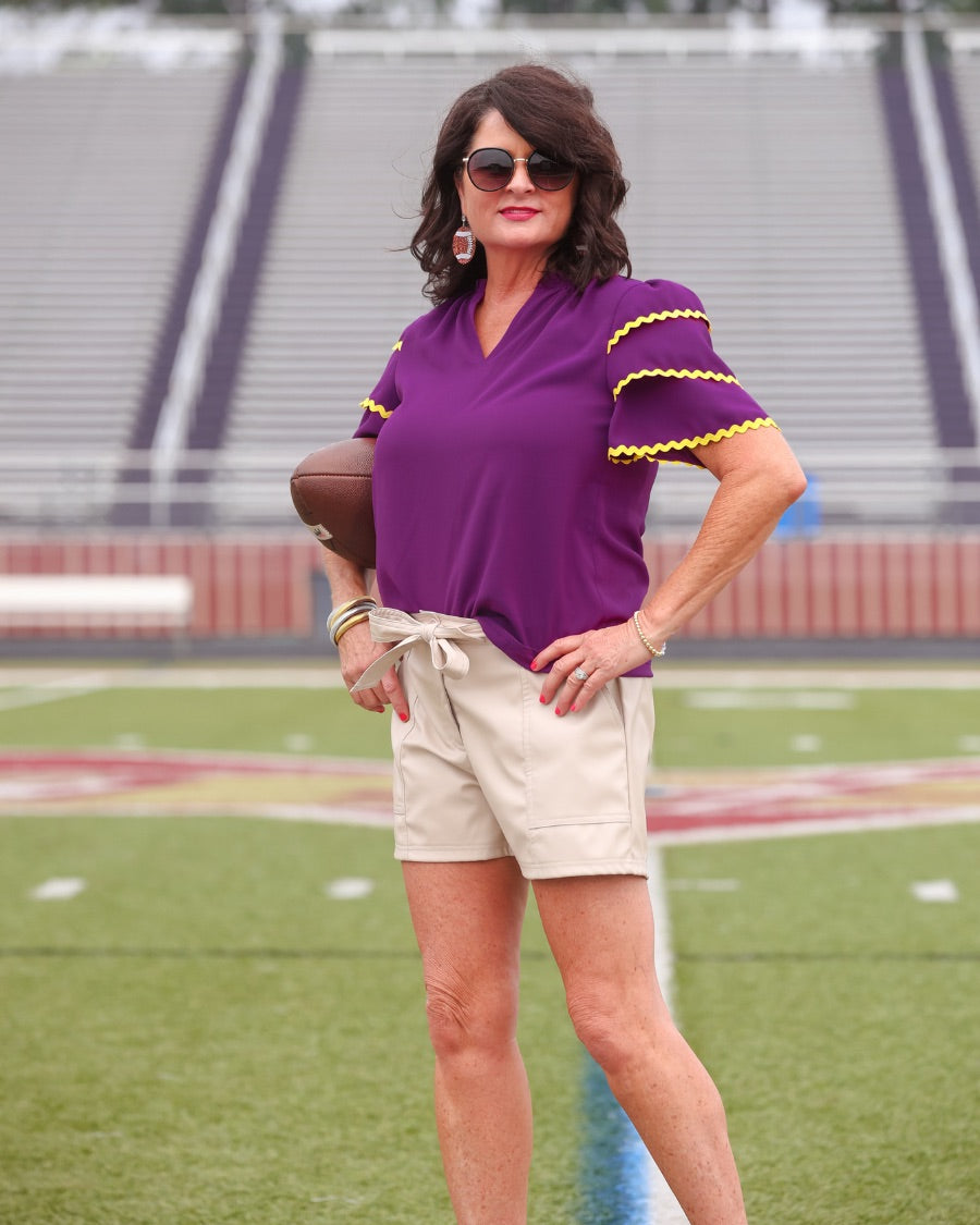 a playful V-neckline top with a ric rac trim detailing on the layered ruffled short sleeves