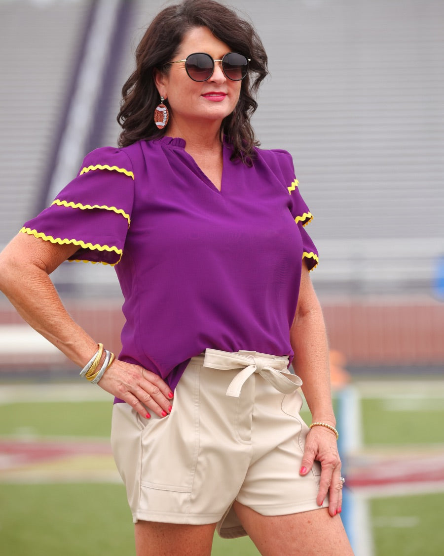 a playful V-neckline top with a ric rac trim detailing on the layered ruffled short sleeves