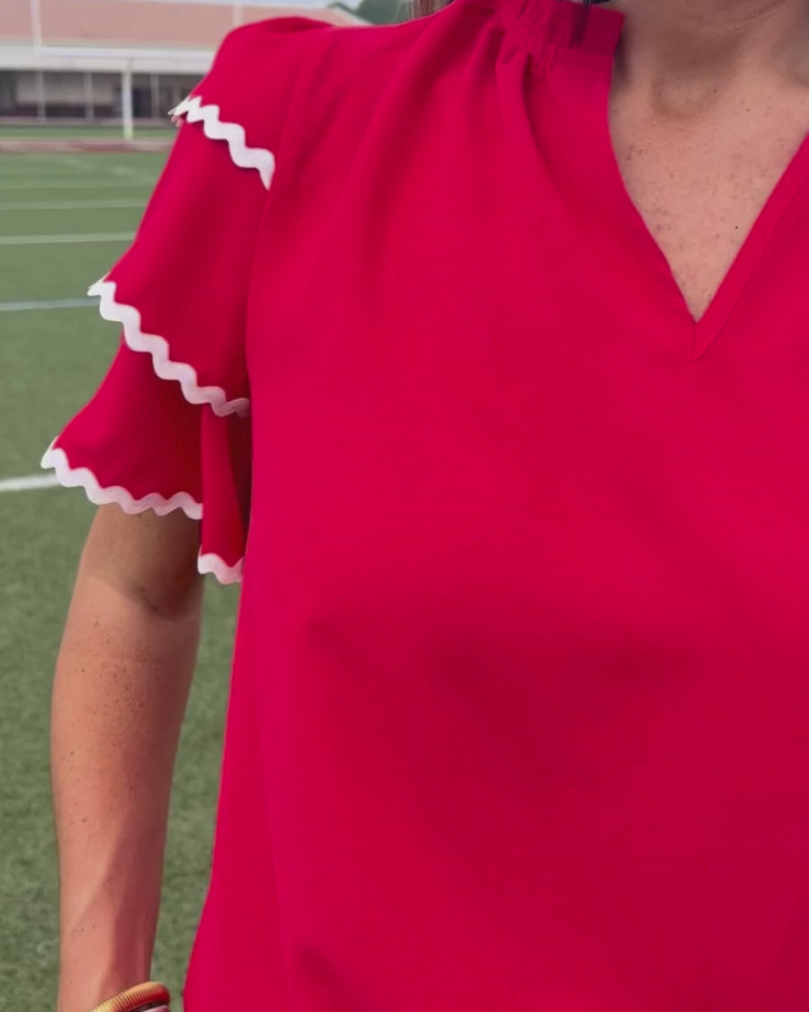 a playful V-neckline top with a ric rac trim detailing on the layered ruffled short sleeves