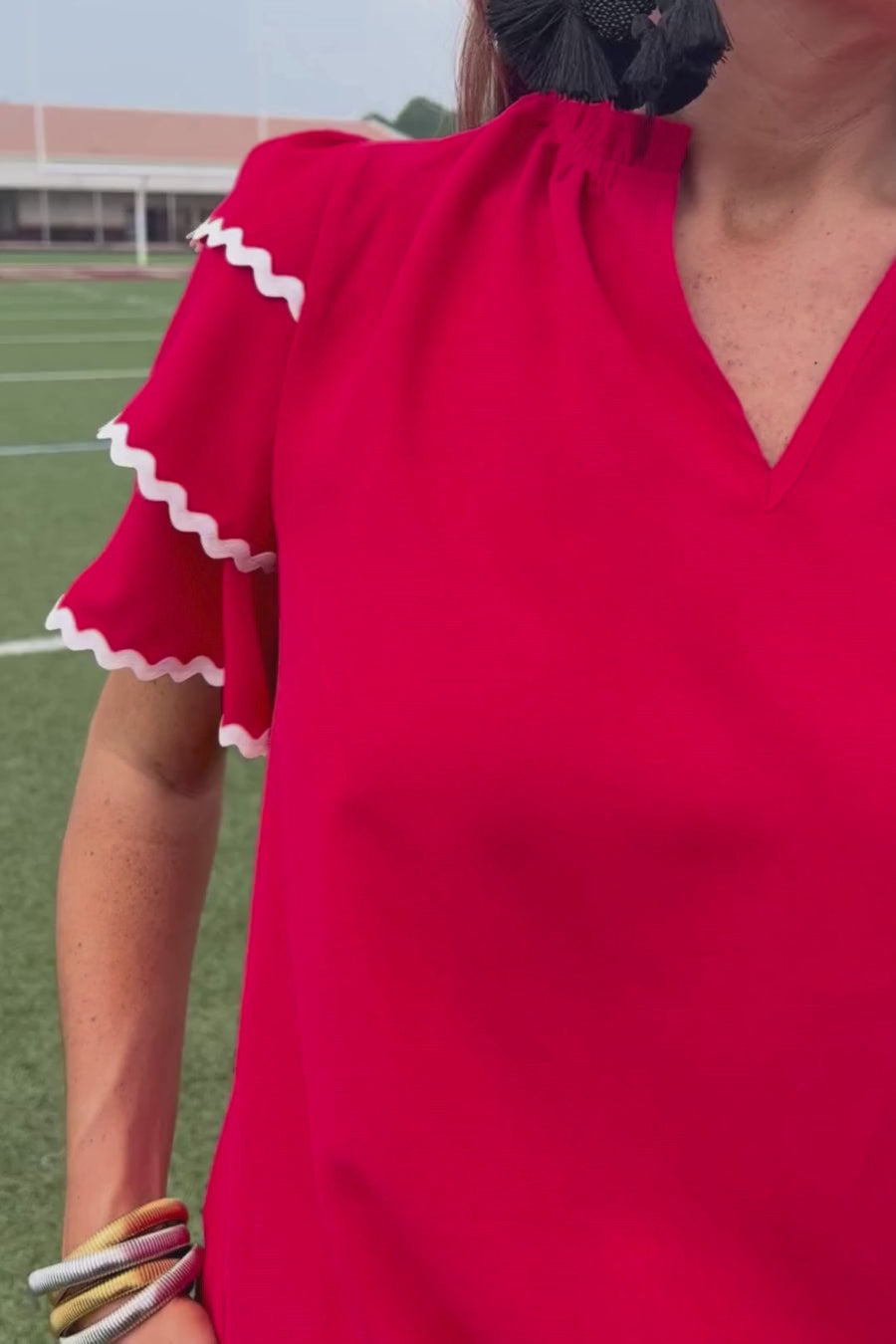 a playful V-neckline top with a ric rac trim detailing on the layered ruffled short sleeves