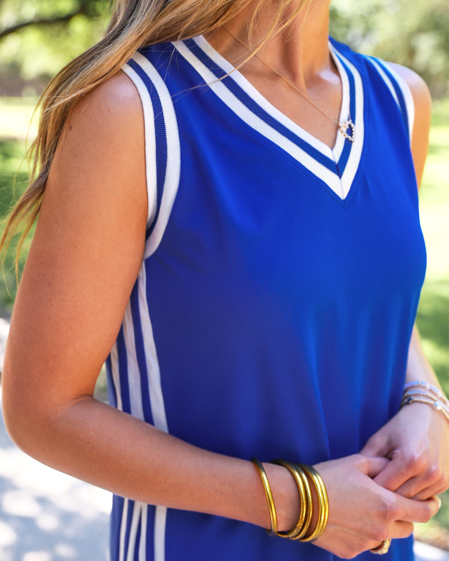 a blue two-piece sleeveless tunic and biker short set with varsity stripe trim, V-neckline, side slits, side pockets, soft stretch fabric, and pre-washed finish
