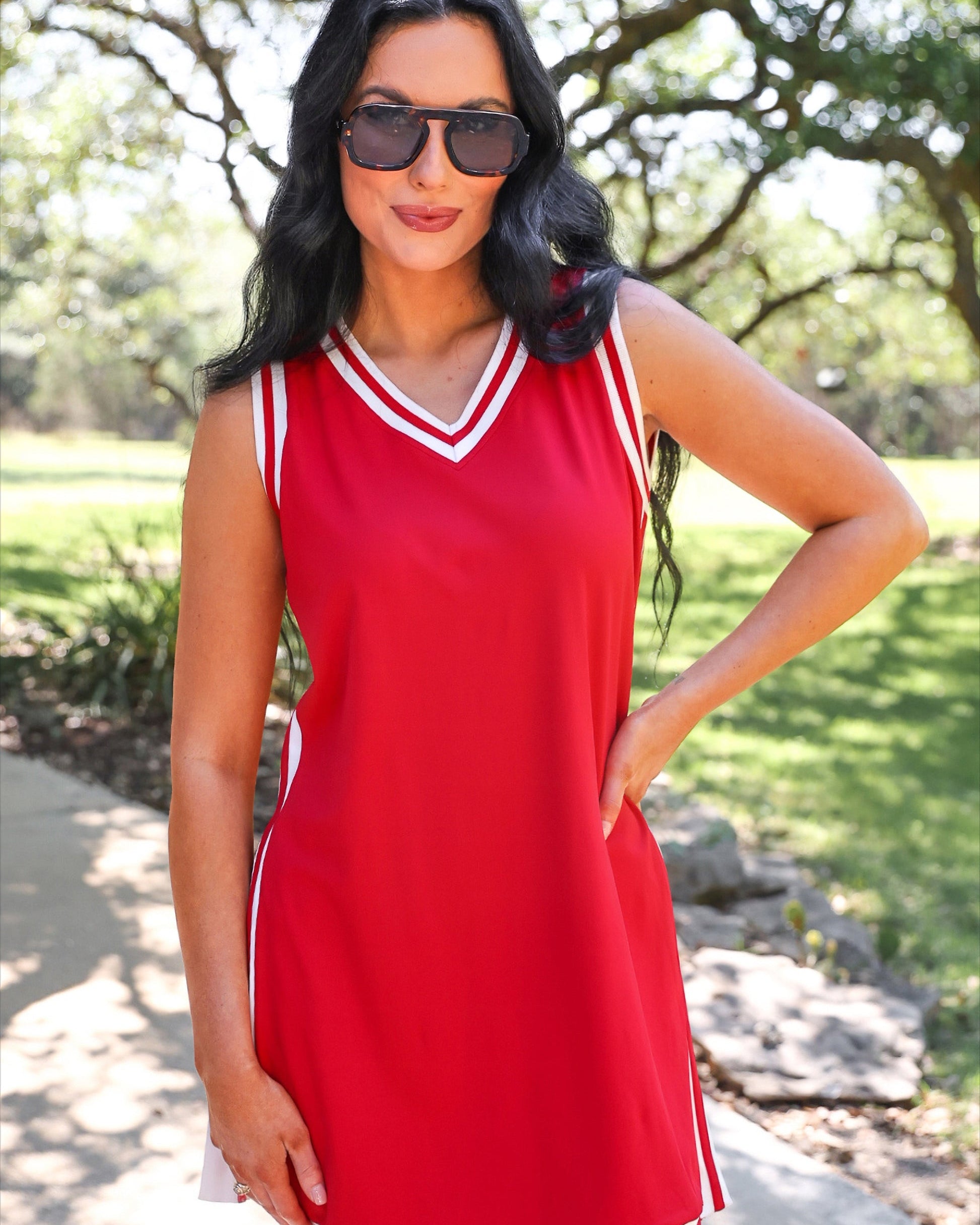 a red two-piece sleeveless tunic and biker short set with varsity stripe trim, V-neckline, side slits, side pockets, soft stretch fabric, and pre-washed finish