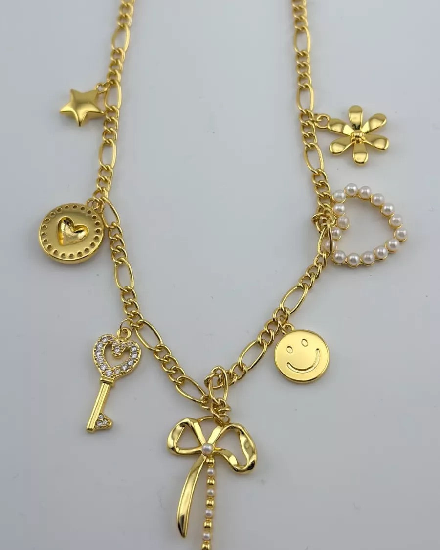 a gold-plated necklace with a stylish chain and seven charms adorned in pearls and rhinestones