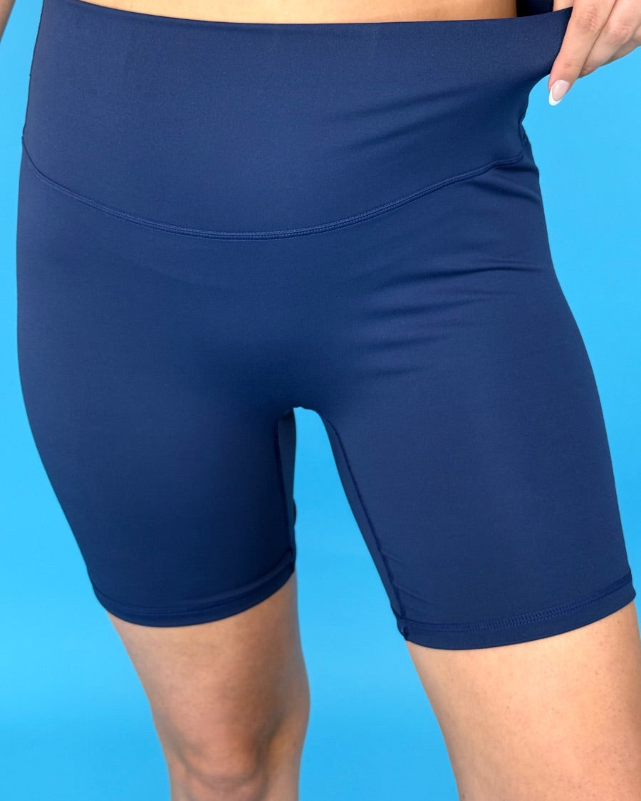 solid navy biker shorts made of buttery-soft, stretchy, and sleek lightweight material with a high elastic waistband and a flattering figure-hugging short silhouette