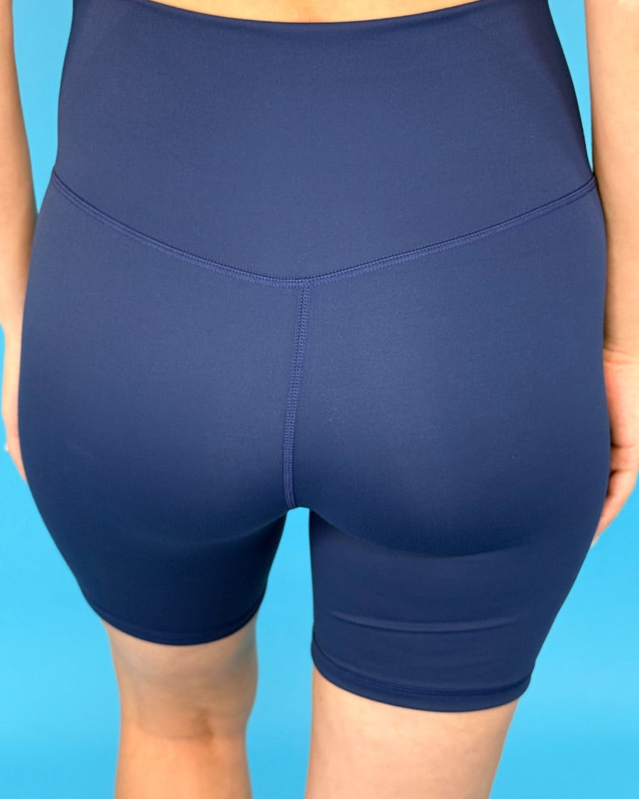 solid navy biker shorts made of buttery-soft, stretchy, and sleek lightweight material with a high elastic waistband and a flattering figure-hugging short silhouette