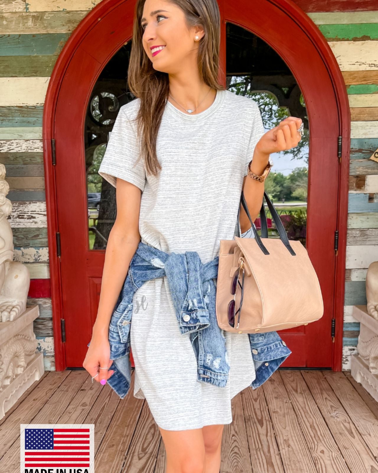 rolled-sleeve dress with a round neckline, hip pockets, and a curved hemline behind a MADE IN USA watermark in the bottom left-hand corner