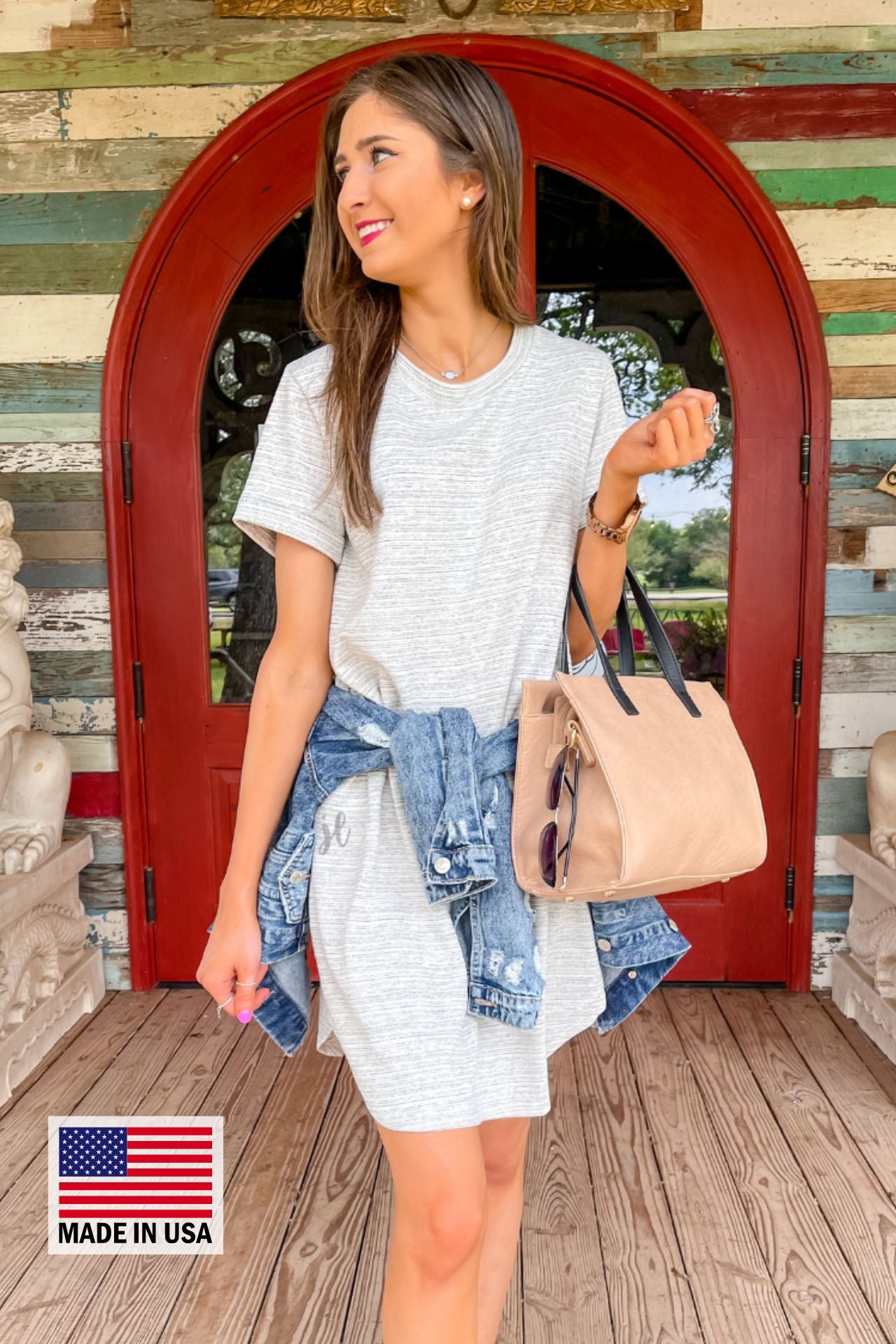 rolled-sleeve dress with a round neckline, hip pockets, and a curved hemline behind a MADE IN USA watermark in the bottom left-hand corner