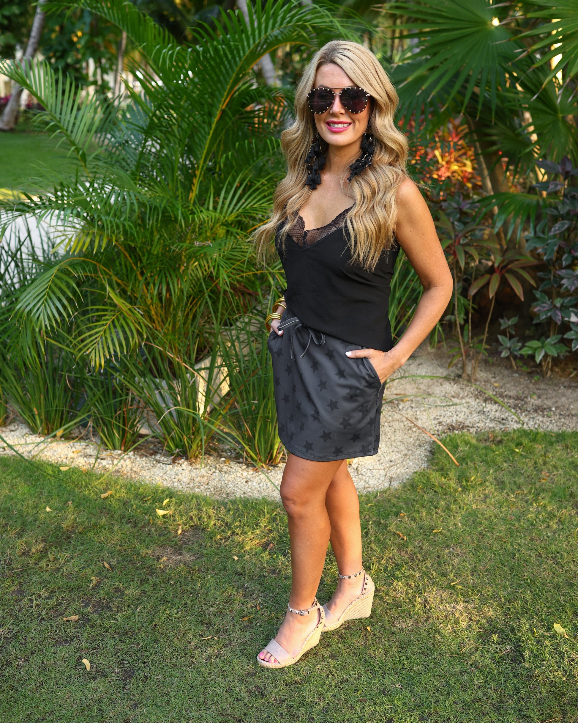 mid-rise relaxed fit everyday skort made of lightweight material with built-in black shorts, drawstring tie, an elastic band on the back, and side pockets, designed on a two-tone black star pattern print