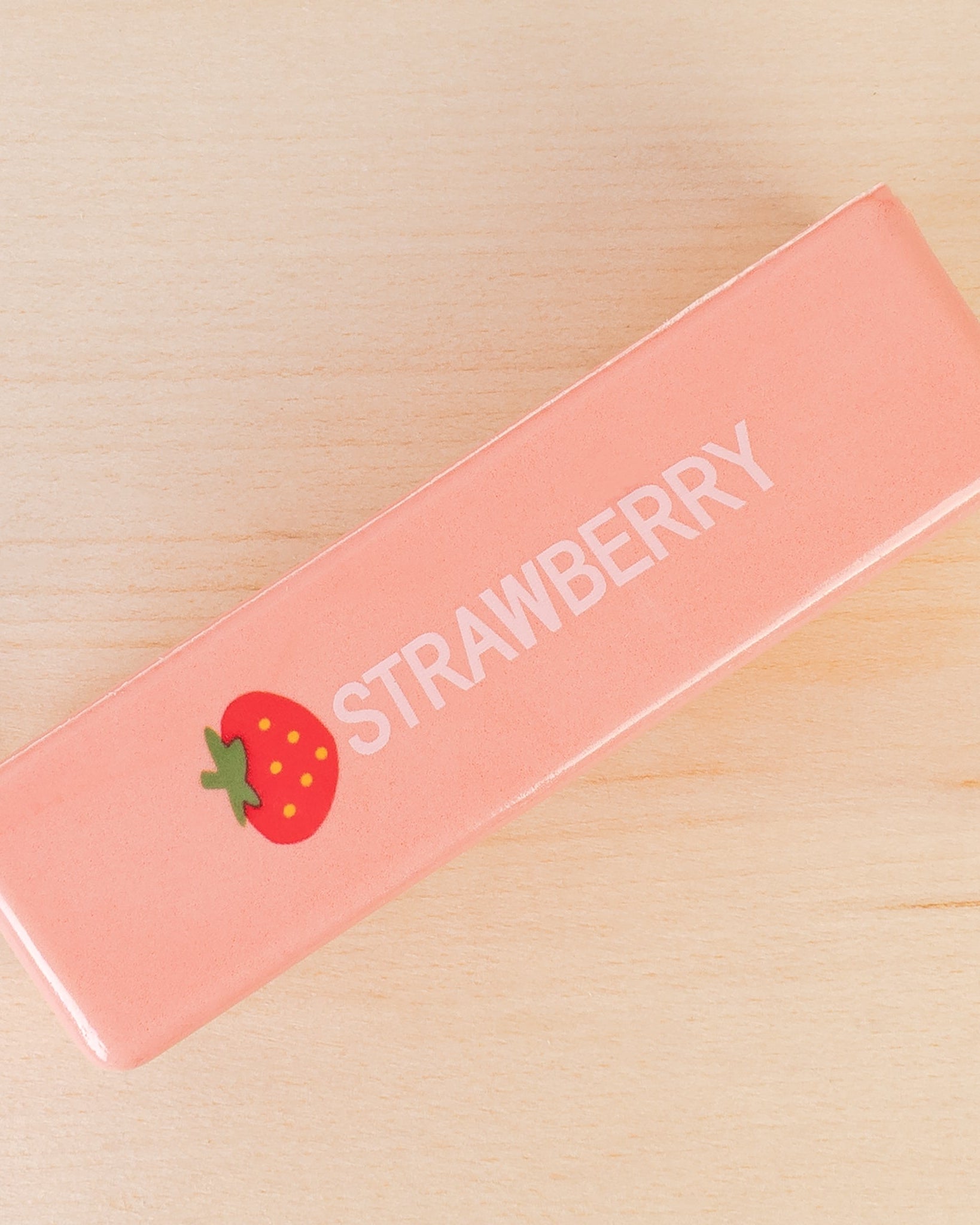 a 4oz strawberry butter-stick inspired foam fidget toy made from slow-rise polyurethane (PU) foam with a soft texture, pastel pink design, a tiny strawberry accent detail, playful printed lettering, and individual packaging