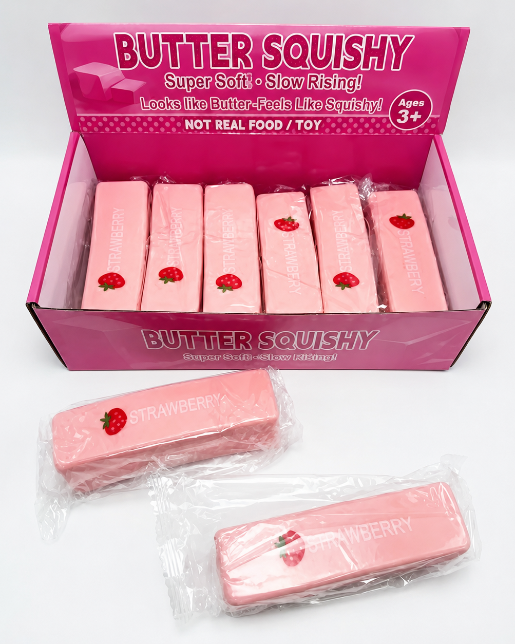 A pink display box labeled 'BUTTER SQUISHY' containing several strawberry-themed squishy bars, with two individually wrapped squishy bars placed in front on a white background.