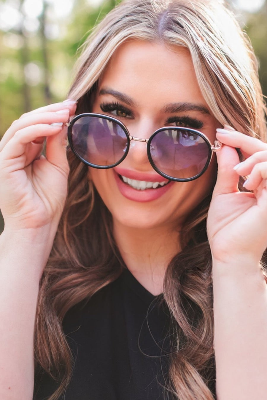 round sunglasses with black and gold wireframes, matching sides, tinted lenses, UV protection, and brand name detail (on both the temple and the complimentary black pouch)