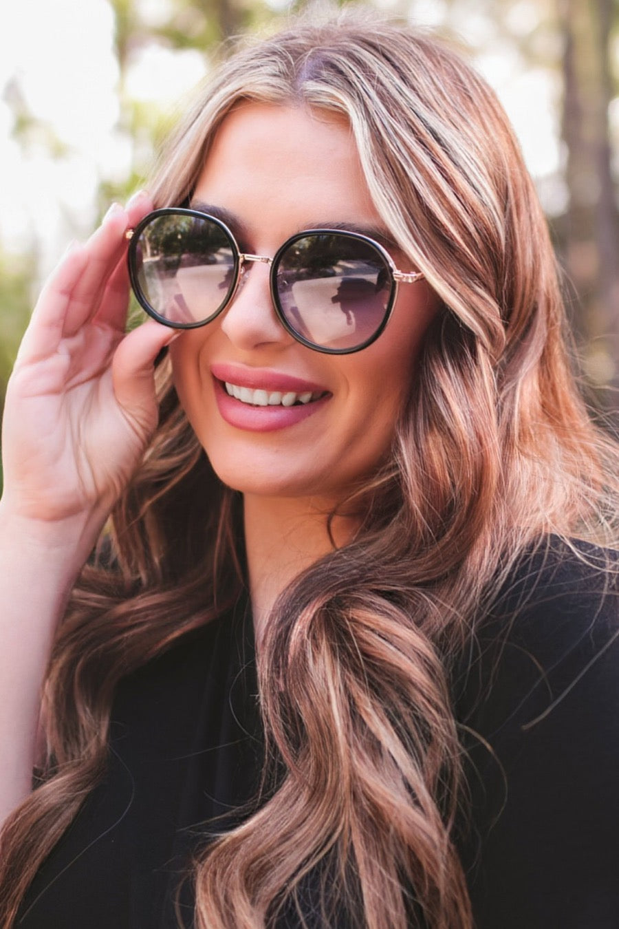 round sunglasses with black and gold wireframes, matching sides, tinted lenses, UV protection, and brand name detail (on both the temple and the complimentary black pouch)