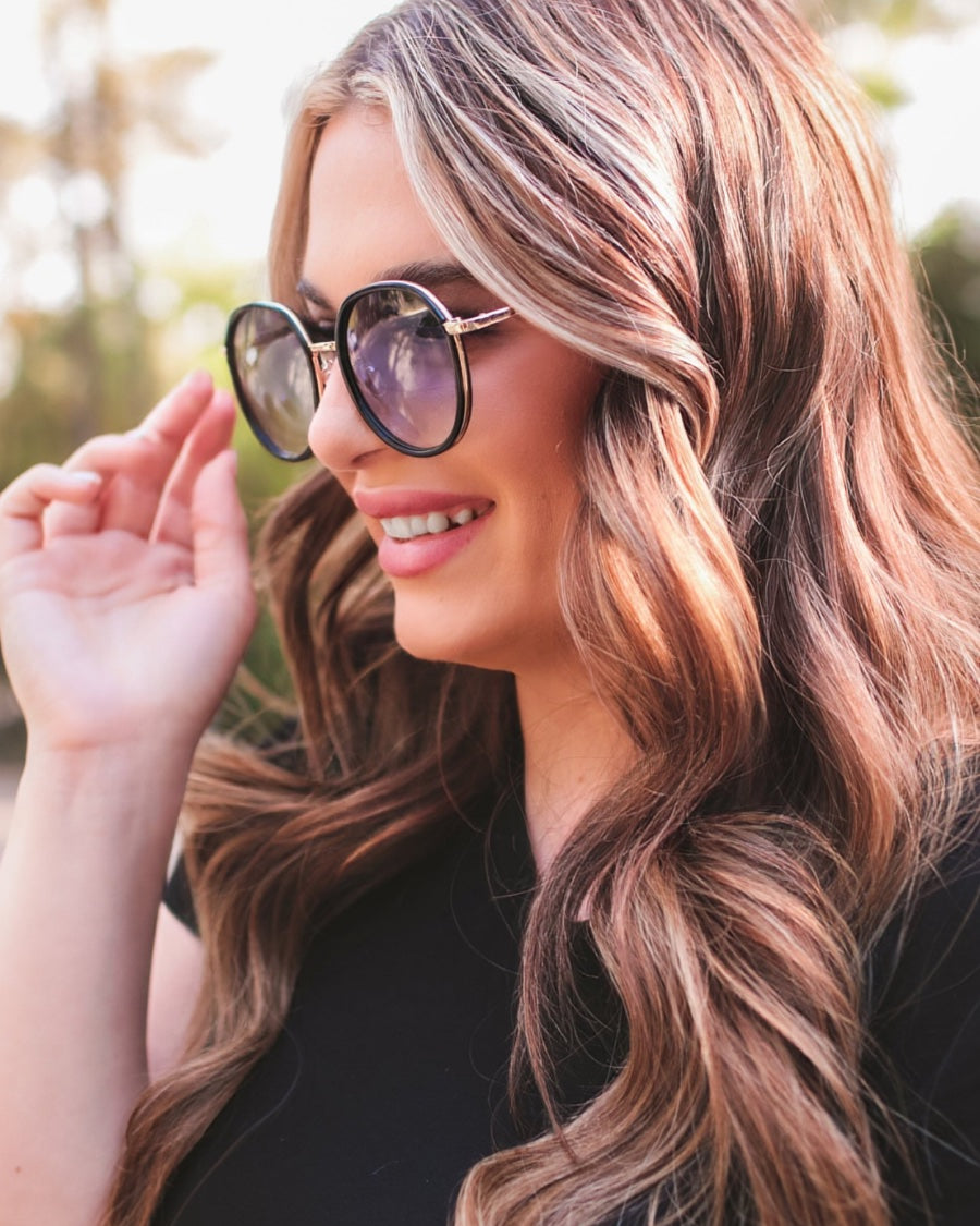 round sunglasses with black and gold wireframes, matching sides, tinted lenses, UV protection, and brand name detail (on both the temple and the complimentary black pouch)