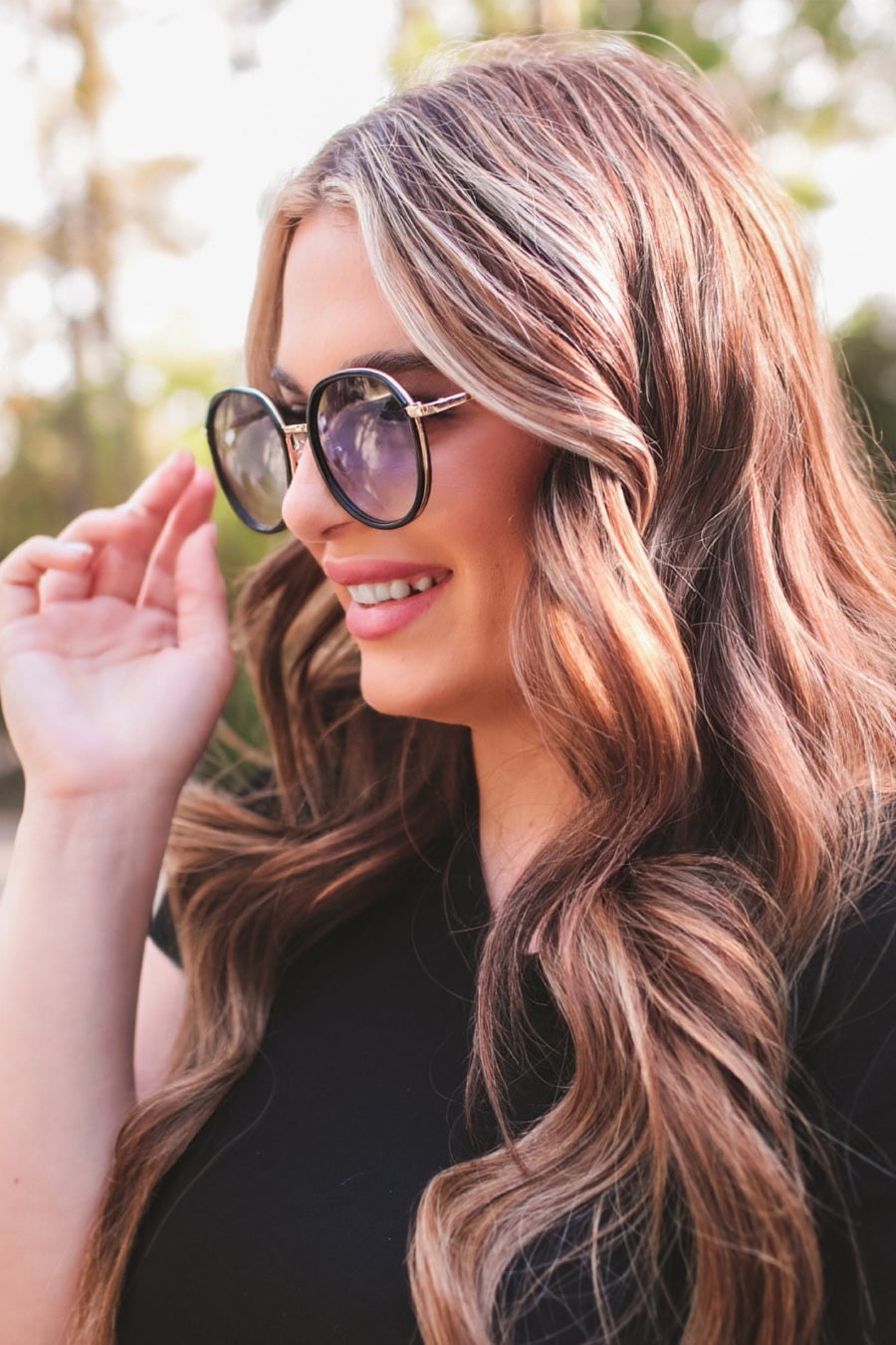 round sunglasses with black and gold wireframes, matching sides, tinted lenses, UV protection, and brand name detail (on both the temple and the complimentary black pouch)